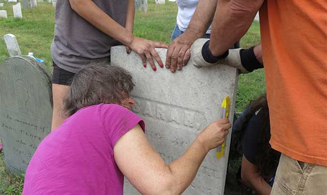 conservation team levels a gravestone