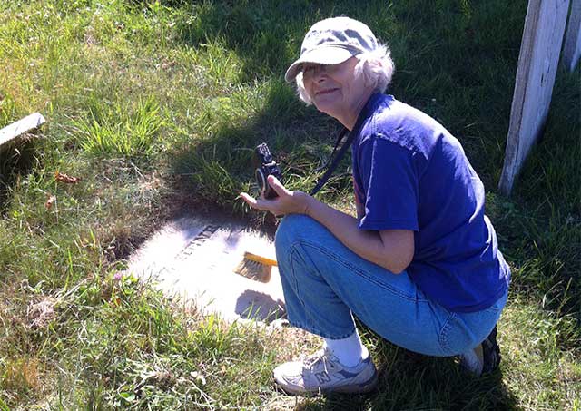 sharon brushes a gravestone