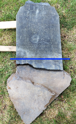 gravestone laying flat on the grass, a line has been drawn across the width area on the stone where the burial line was carved