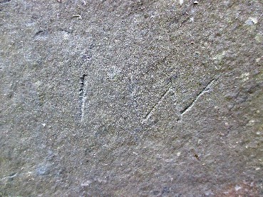 magnified detail of initials scratched into a slate stone
