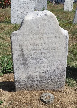 standing carved marble gravestone with plot marker in front of it