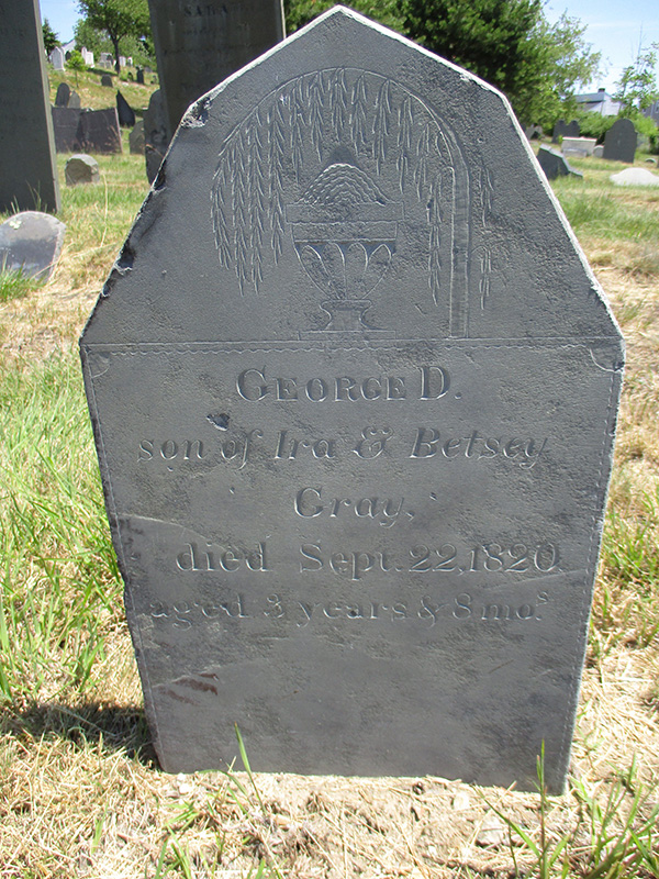 Gray slate gravestone whose top is pointed and corners trimmed, carved with an urn and willow design. Center of stone carving says: George D. son of Ira and Betsey Gray, died Sept. 22, 1820, aged 3 years and 8 months 