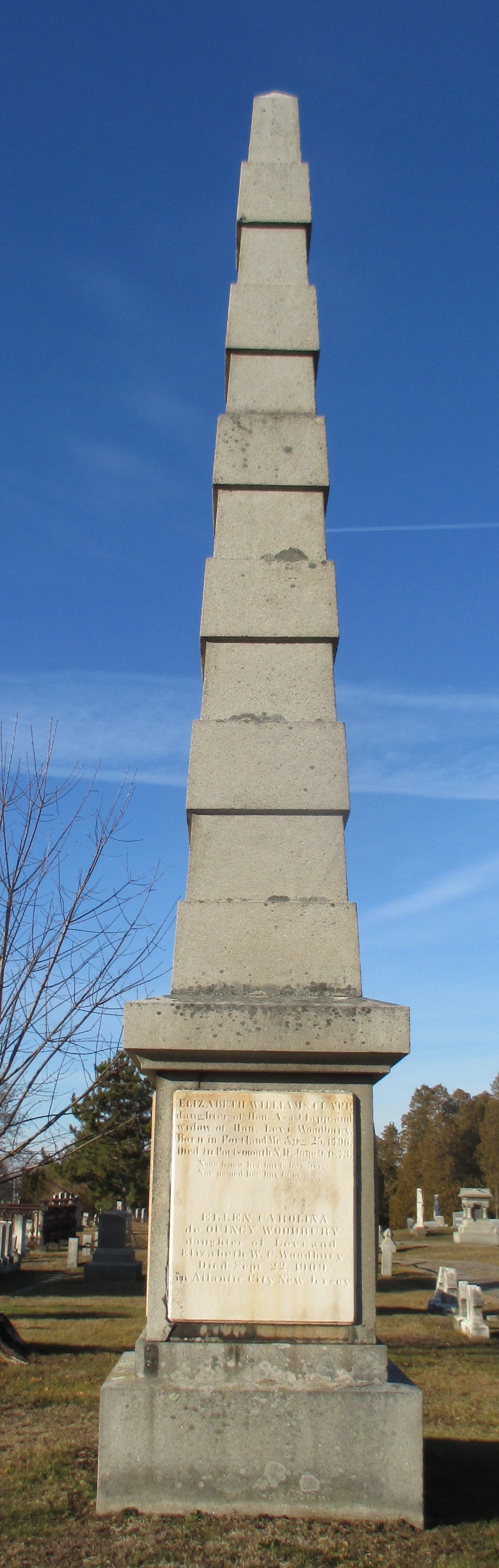 large granite and marble obelisk monument with 5 bands around it